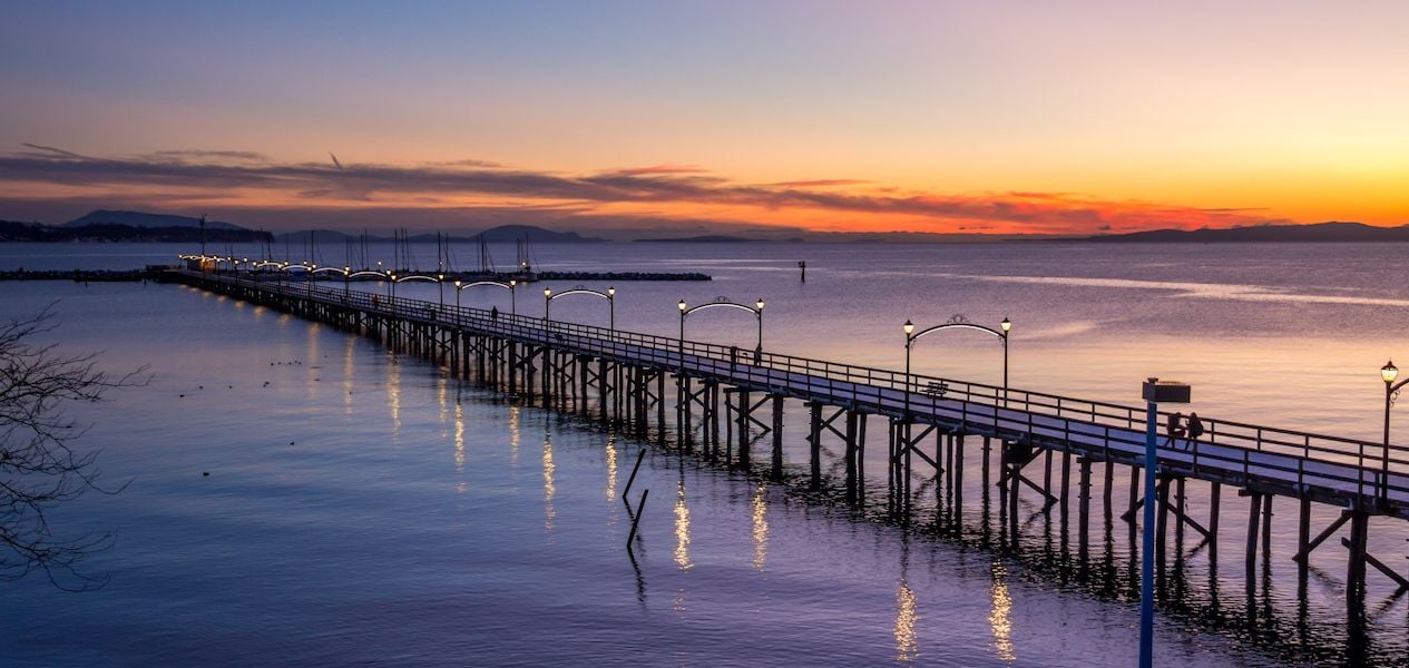 Cầu cảng White Rock Pier vươn mình ra biển, với bầu trời xanh và những đám mây trắng