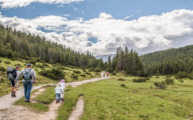 Du khách đang hiking trên con đường mòn giữa núi non hùng vĩ tại Vườn Quốc gia Thụy Sĩ